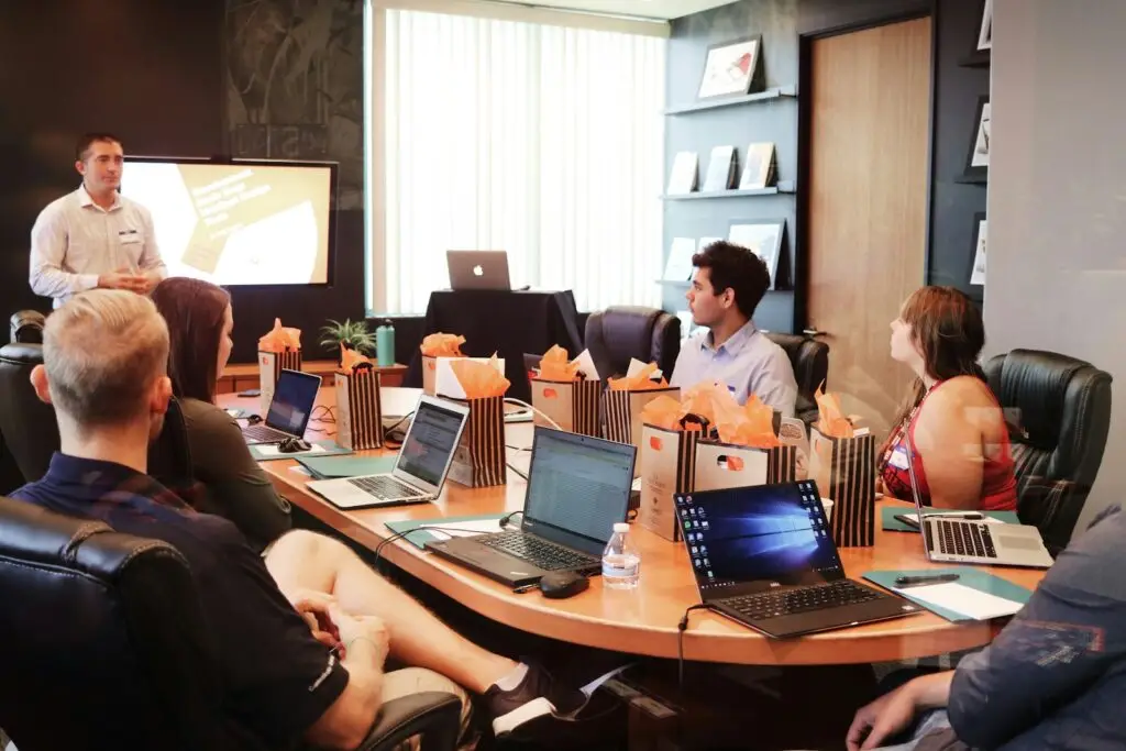 IT consultant presenting to a team with laptops