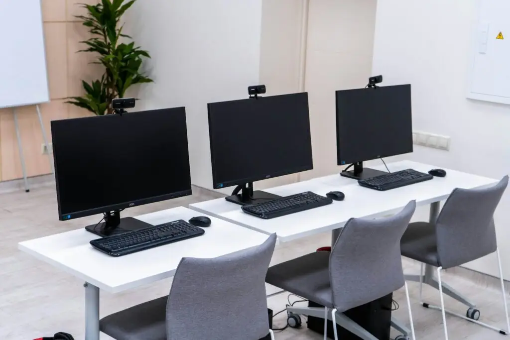 Windows 11 24H2 end of support: row of office desktop workstations ready for updating